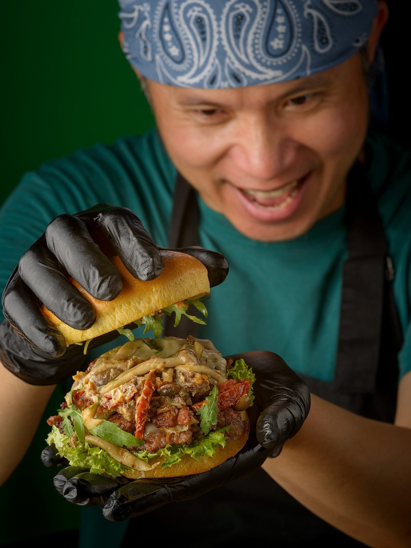 KOYA chef smiling with a smash burger